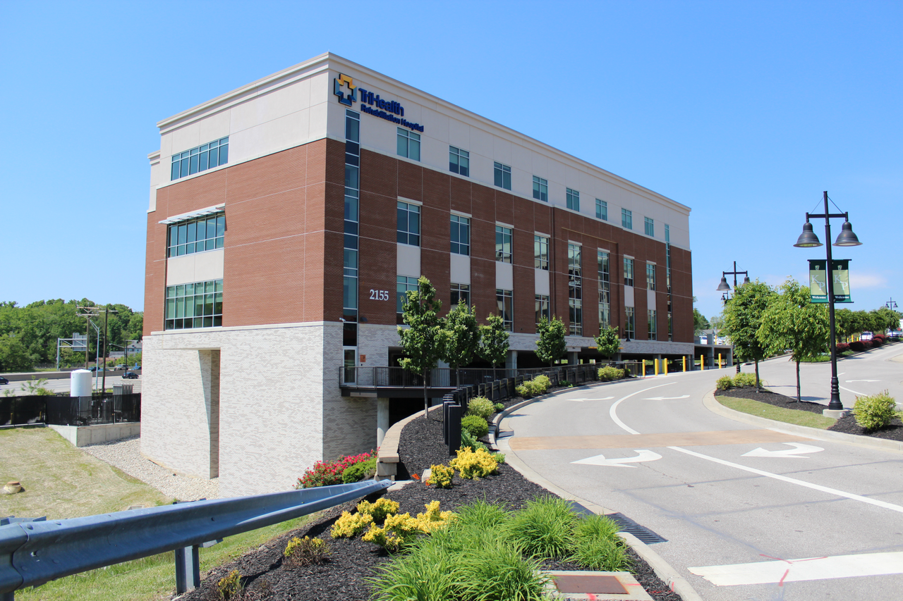 Modern brick office building with landscaping and a clear blue sky.