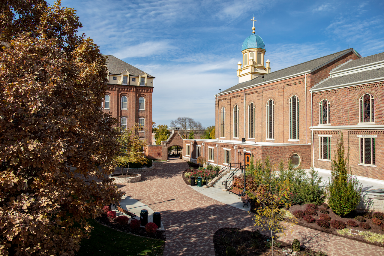 Brick campus buildings with a courtyard and a blue sky.
