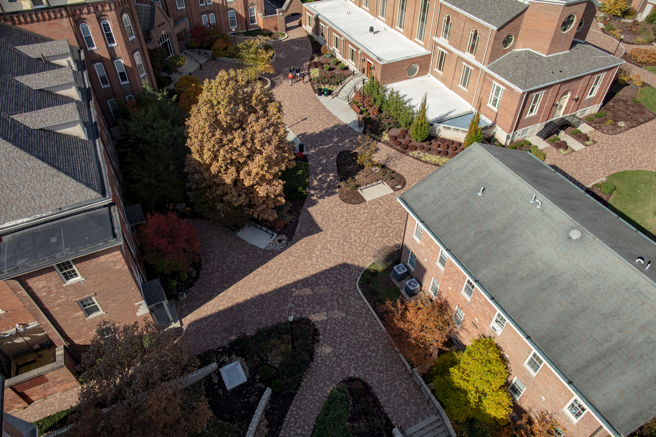 Aerial view of brick buildings and autumn trees in a courtyard.