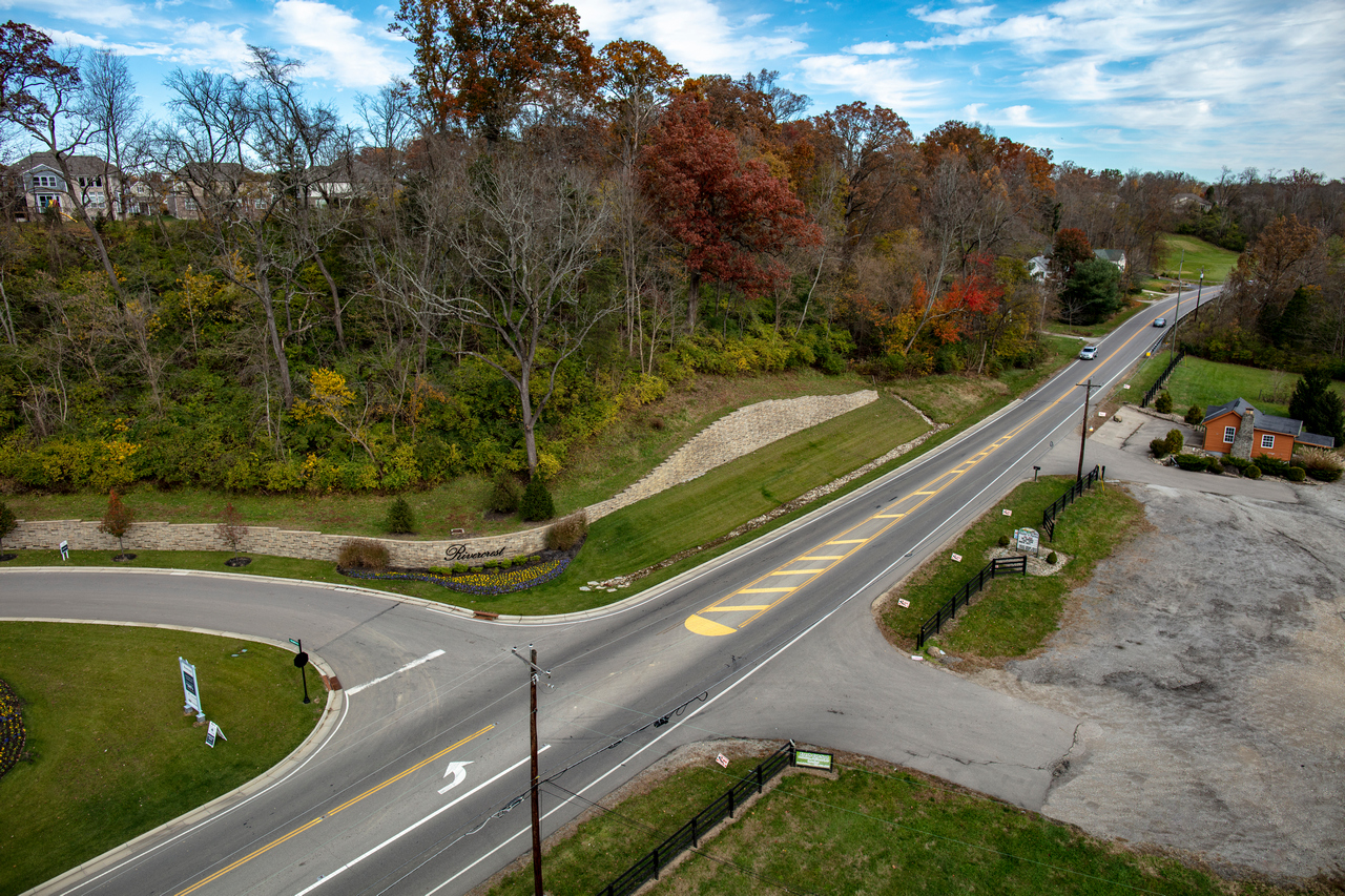 Aerial view of a quiet road intersection surrounded by autumn trees.