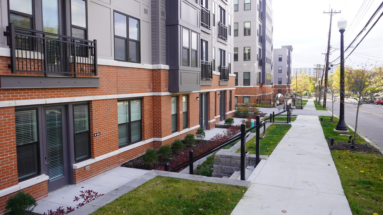 Modern apartment building with a landscaped walkway and green lawns.