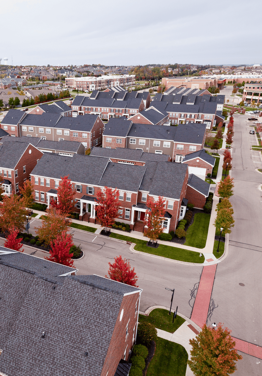 Aerial view of suburban houses with autumn trees lining the streets.