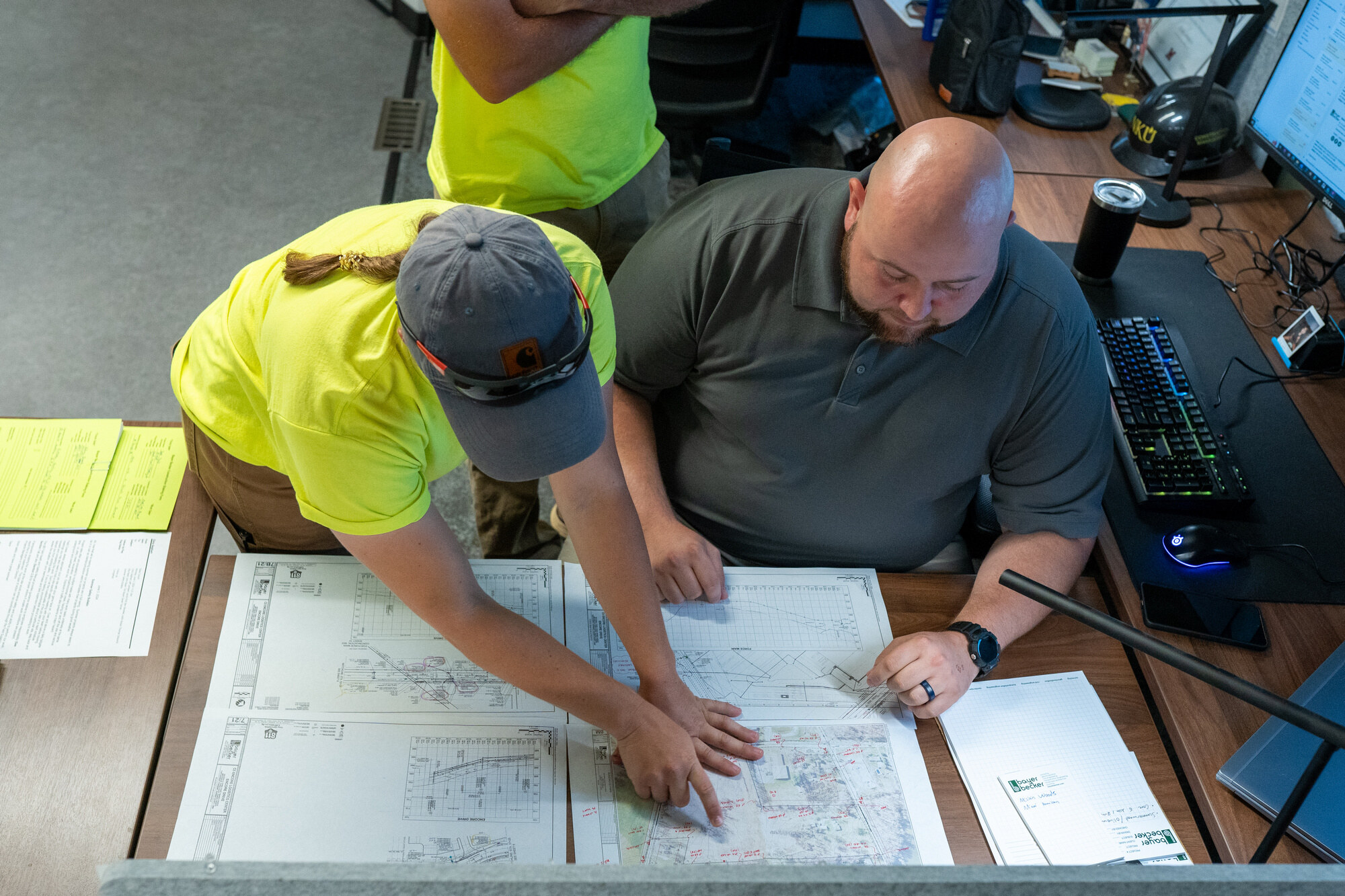 Bayer Becker Careers Two people reviewing large architectural plans at a desk.