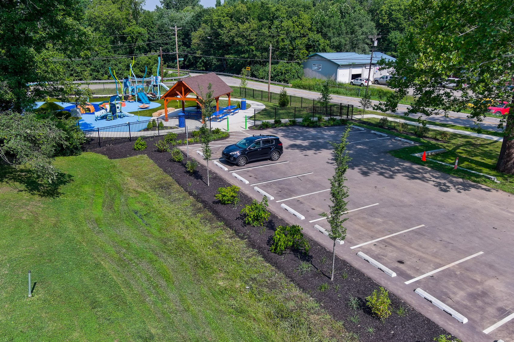 Aerial view of a park with parking spaces and a green lawn.