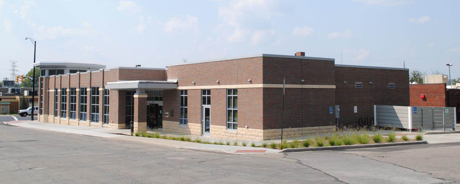 back of the brick library building with green plants