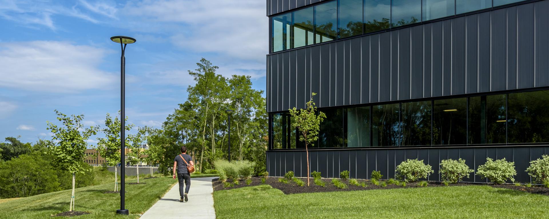 person walking on a path near an office building