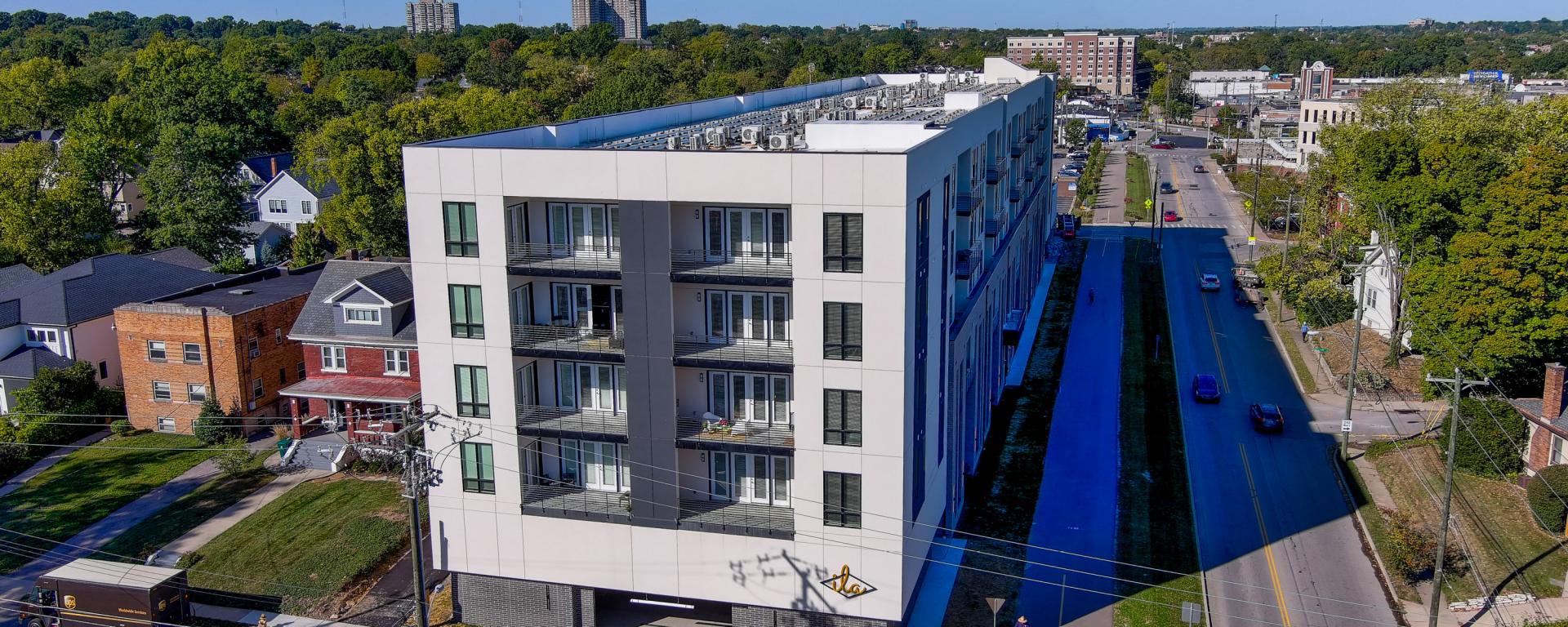 aerial photo of apartment building with balconies next to running path