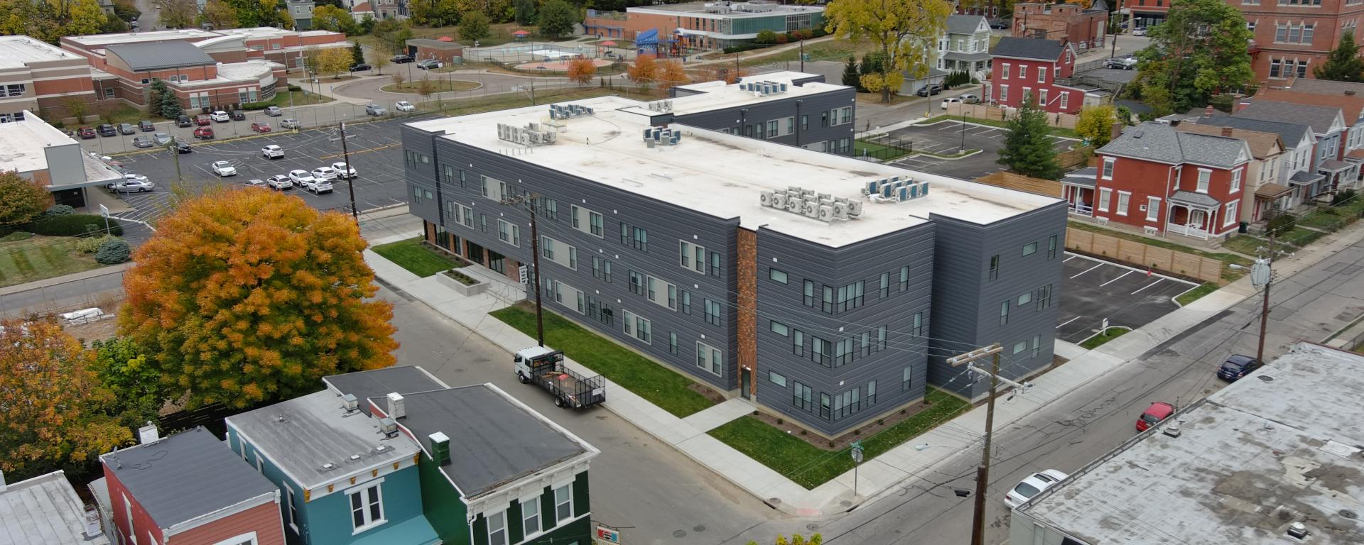 Aerial photo of a gray apartment building in urban neighborhood