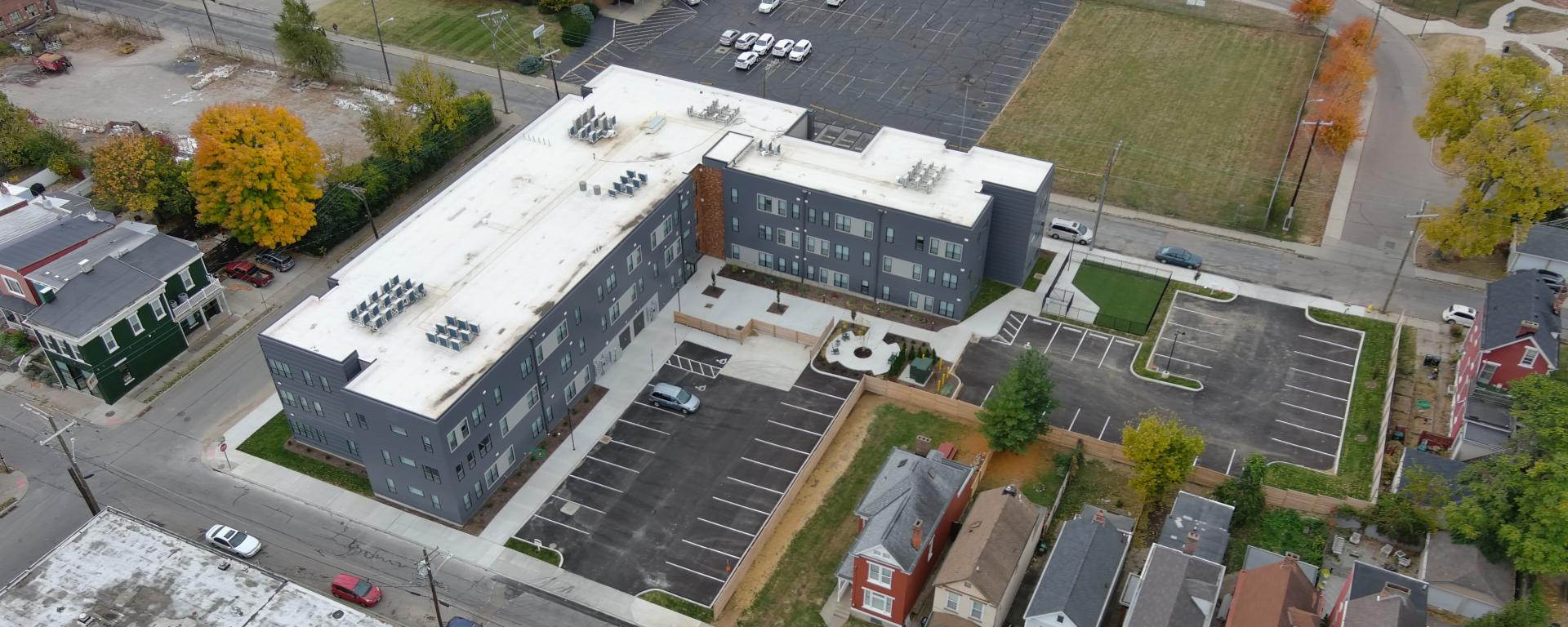 Aerial photo of a gray apartment building in urban neighborhood