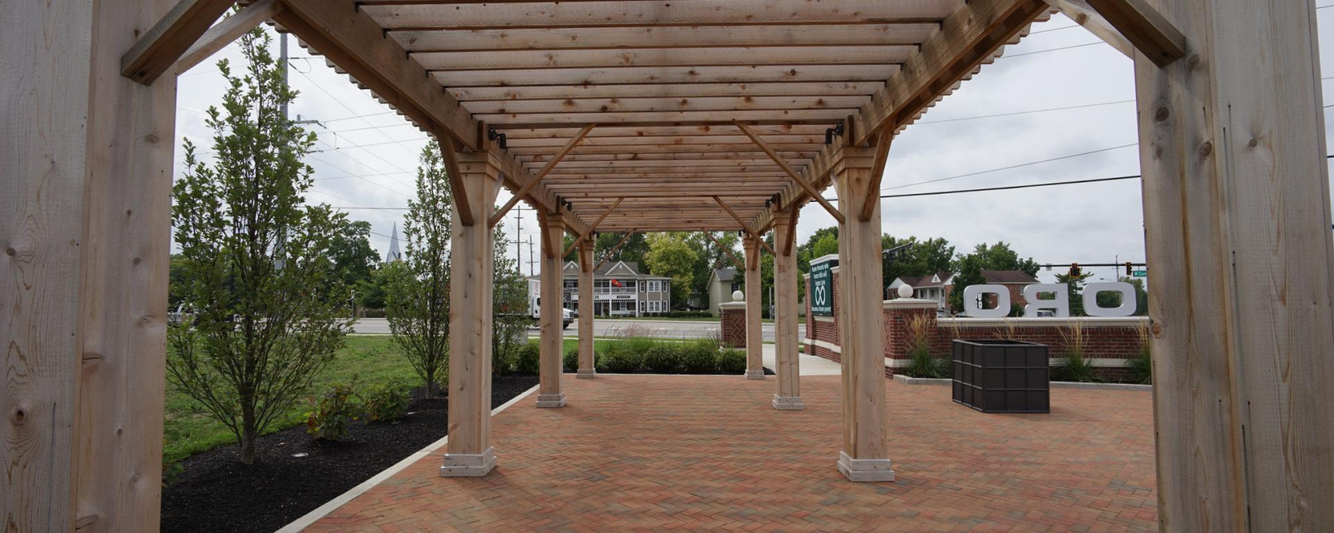 wooden pergola structure with green trees outside