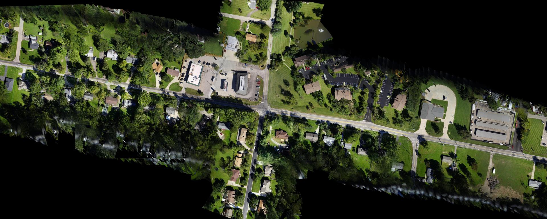 aerial photo of roadway intersection with houses on all sides