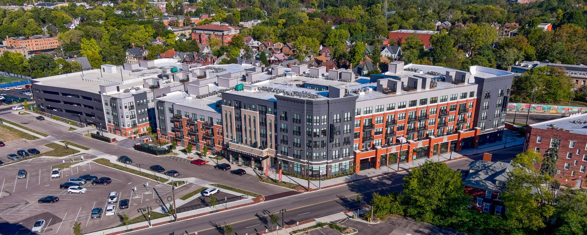 aerial photo of apartment building with parking garage in urban neighborhood
