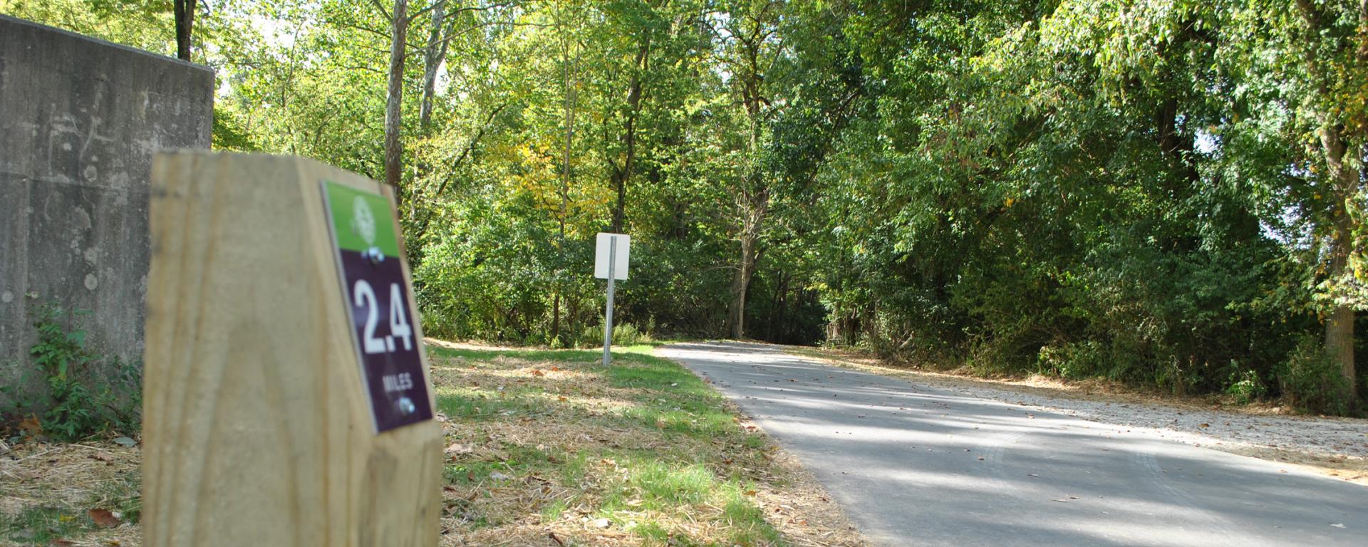 mile marker next to a paved trail