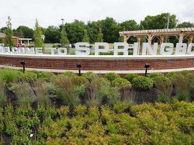 welcome sign with green plants surrounding