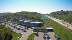aerial of facility and parking lot, featuring highway in the back